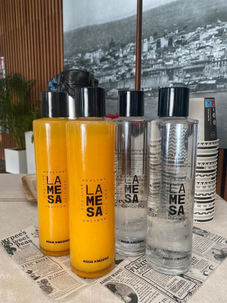 Botellas de zumo de naranja natural y agua de La Mesa con Live Healthy