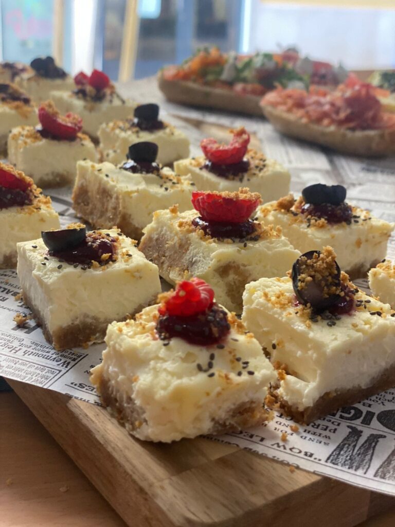Mini cheesecakes con frutos rojos sobre tabla de madera, postres de La Mesa