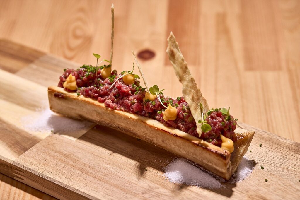 Tartar servido sobre hueso con micro brotes y crujiente en La Mesa, Palma de Mallorca