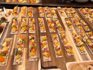 Tablas de madera con tostas de hummus y verduras de colores para evento en Palma