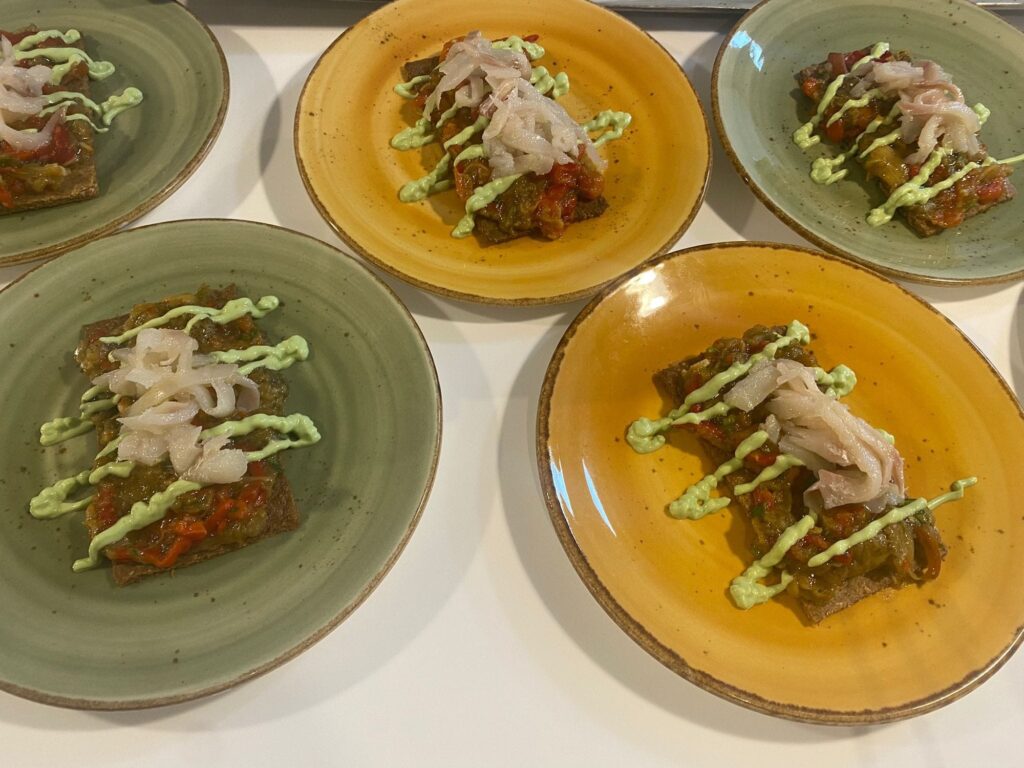 Tostas de verduras con cebolla y salsa de aguacate en platos de cerámica, La Mesa